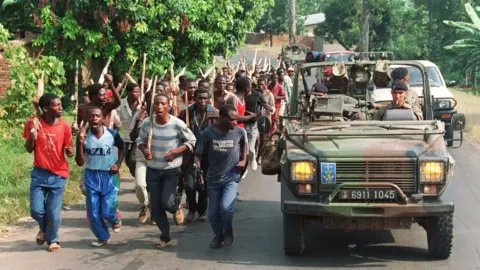 AlexMvuka's tweet photo. La haine contre les Tutsi en RDC constitue un cadre d'analyse permettant de comprendre le négationnisme du génocide contre les Tutsi au Rwanda.

Le négationnisme d'un génocide consiste à nier, à minimiser ou à tenter de justifier la réalité historique d'un génocide reconnu.

Dans la région des Grands Lacs, le négationnisme du génocide contre les Tutsi au Rwanda est relativement peu abordé dans les débats publics.

Pour de nombreux Congolais, le génocide contre les Tutsi au Rwanda est moins un génocide établi et reconnu en droit international qu'une tragédie ayant bénéficié d'une attention particulière de la communauté internationale. Cette perception s'inscrit dans un contexte historique marqué par la discrimination dont ont été victimes les Tutsi congolais, autrefois Zaïrois puis Congolais. Bien avant la guerre du Rwanda (1990-1994), ils étaient déjà confrontés à l'exclusion, à des violences et à des contestations de leur citoyenneté. 

La plupart des leaders de la société civile congolaise n'ont jamais reconnu le génocide contre les Tutsi au Rwanda. Paradoxalement, le Rwanda dirigé par le MRND était accepté, alors que, dès son arrivée au pouvoir, le Rwanda dirigé par le FPR ne l'était pas.

En 1994, l'Église catholique congolaise a ouvert ses diocèses pour accueillir les milliers de réfugiés rwandais hutu. Au même moment, des prêtres ont accompagné le cortège des déportations de Tutsi congolais vers le Rwanda.

Considérant que la qualification de génocide contre les Tutsi au Rwanda est perçue par de milliers en RDC comme un privilège, de nouveaux vocables, tels que « Genocost », sont aujourd'hui proposés pour établir une forme de concurrence entre les tragédies et revendiquer une reconnaissance équivalente, voire supérieure, de leur propre souffrance.

Ces manœuvres ignorent la définition juridique du génocide, qui repose sur l'intention de détruire, en tout ou en partie, un groupe national, ethnique, racial ou religieux déterminé. 

Au cours des trente dernières années, la RDC a connu plusieurs centaines de milliers de morts. La majorité de ces décès sont attribués aux conséquences directes et indirectes des conflits armés ainsi qu'à la mauvaise gouvernance. D'autres victimes, notamment parmi les Tutsi et les Hema, ont été tuées en raison de leur identité. Cette dernière catégorie de victimes n'est toutefois pas prise en compte dans le concept de « Genocost ».

Une attitude fondée sur la contestation de la nationalité des Tutsi congolais, associée à une vision politique ethnocentrique et à la haine envers les Tutsi, contribue à comprendre les campagnes et les manifestations de négationnisme du génocide contre les Tutsi au Rwanda.
