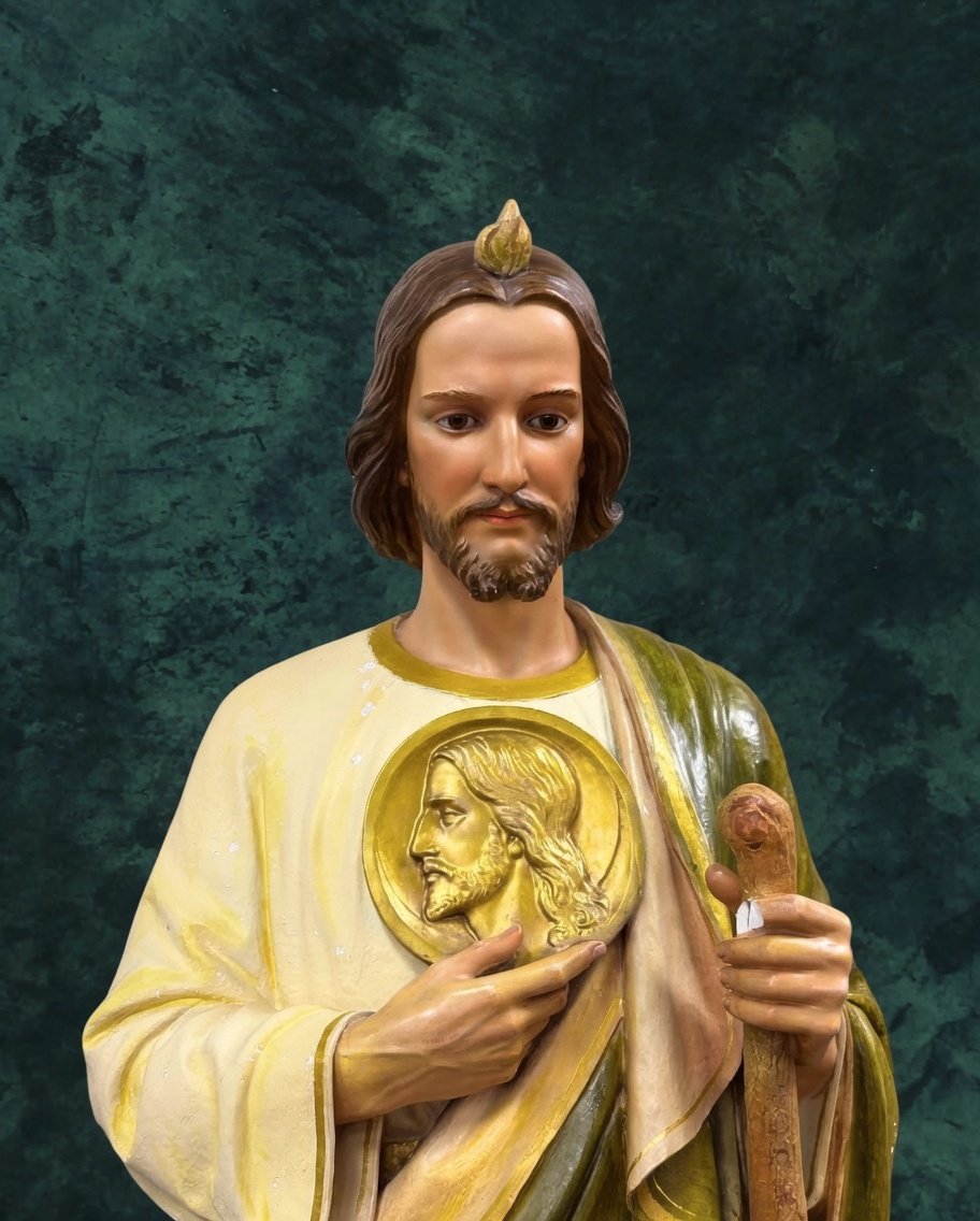 JustAdaugoijele's tweet photo. Why does Saint Jude Thaddeus Icon depicted wearing a big medallion?"

Saint Jude Thaddeus, one of the Twelve Apostles and the patron saint of hopeless causes, is traditionally depicted in Catholic iconography wearing or holding a large medallion around his neck.
This medallion features an imprinted image of Jesus Christ's face and serves as a key symbol in his representations.

T he medallion originates from story tied to the Image of Edessa, also known as the Mandylion, an acheiropoietos (not made by human hands) cloth bearing Christ's face. According to tradition:
King Abgar V of Edessa (in modern-day Turkey) suffered from a severe illness and wrote a letter to Jesus requesting healing.
Jesus replied that he could not visit but promised to send a disciple.

After the Ascension, St. Jude Thaddeus traveled to Edessa, carrying either a cloth imprinted with Christ's face (pressed against it during the Passion) or a folded portion of the Shroud of Turin showing only the face.
Jude presented this image to the king, who was miraculously healed upon seeing it, leading to the conversion of Edessa to Christianity.

This act established Jude as a bringer of healing and hope in desperate situations, reinforcing his role as patron of impossible causes. The medallion thus symbolizes:
. Christ's healing power channeled through Jude.
. St. Jude's devotion and role as an intercessor.
. Faith in divine intervention when all seems lost.

The medallion is often shown as a round pendant or cloth draped over his chest, sometimes held in his hand.
It pairs with other symbols like a club (his martyrdom instrument), a scroll (his Epistle in the New Testament), or green robes (for hope).
