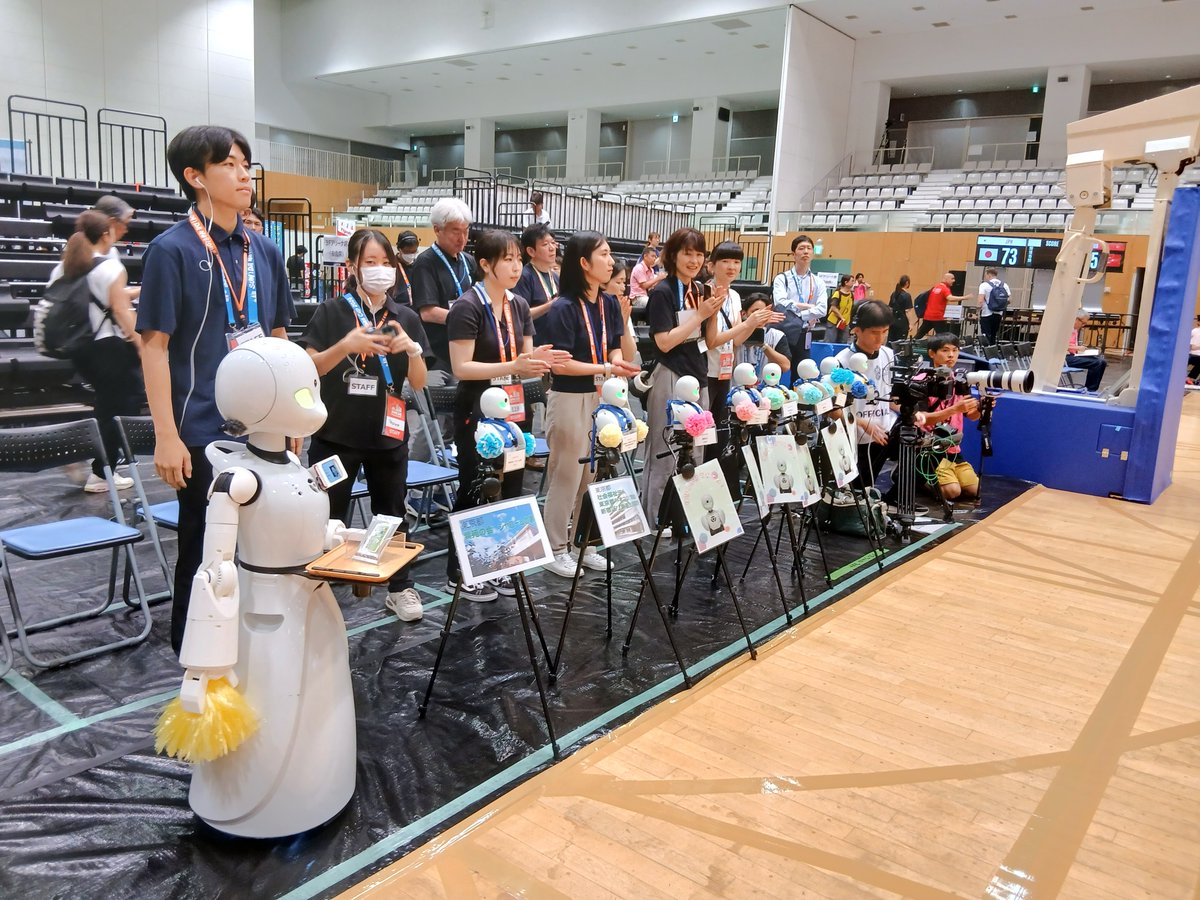 OryLaboratory's tweet photo. 東京都パラスポーツリモート参加事業
車いすバスケットボール SUMIDA Nations Cup 2026 in Tokyo 観戦🏀♿

東京都「パラスポーツリモート参加事業」の一環として、分身ロボットOriHime・OriHime-Dが「車いすバスケットボール SUMIDA Nations Cup 2026 in Tokyo」日本対トルコ戦の観戦に参加しました！

コート際の特等席で観戦し、試合は日本代表が73-45で勝利🏀
OriHimeのまわりには学校観戦の小学生が座り、パイロットとの交流も。挨拶を交わしたり、「ニッポン！」の声援にあわせて一緒に応援したり、素敵なひとときになりました🙌

試合終了後には、退場する日本代表選手とハイタッチ
「ありがとうございました」と労いの言葉をお伝えしました✨

最後は来場者のみなさまをお見送り。たくさんの方が手を振って送り出してくれました👏

#パラスポーツ #分身ロボット