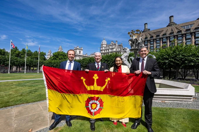 Commons Speaker with a group of Hampshire MPs posing with Hampshire flag in New Palace Yard.
