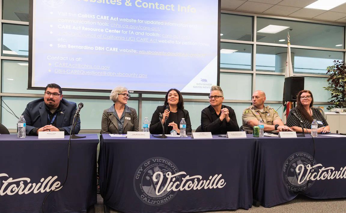 Panelists speak at a CARE Act community information session in Victorville with a presentation screen and audience discussion.

Left to right: William Lamas, Homelessness Solutions Manager of Victorville, Judge Michelle H. Gilleece of San Bernardino Superior Court; Anna Mejia, program manager of San Bernardino County Department of Behavioral Health; Dr. Alyce Belford-Saldana, Deputy Director of the San Bernardino County Department of Behavioral Health; Lieutenant Benjamin Henry of San Bernardino County Sheriff’s Department; and Michelle Brown of the Legal Aid Society of San Bernardino.
