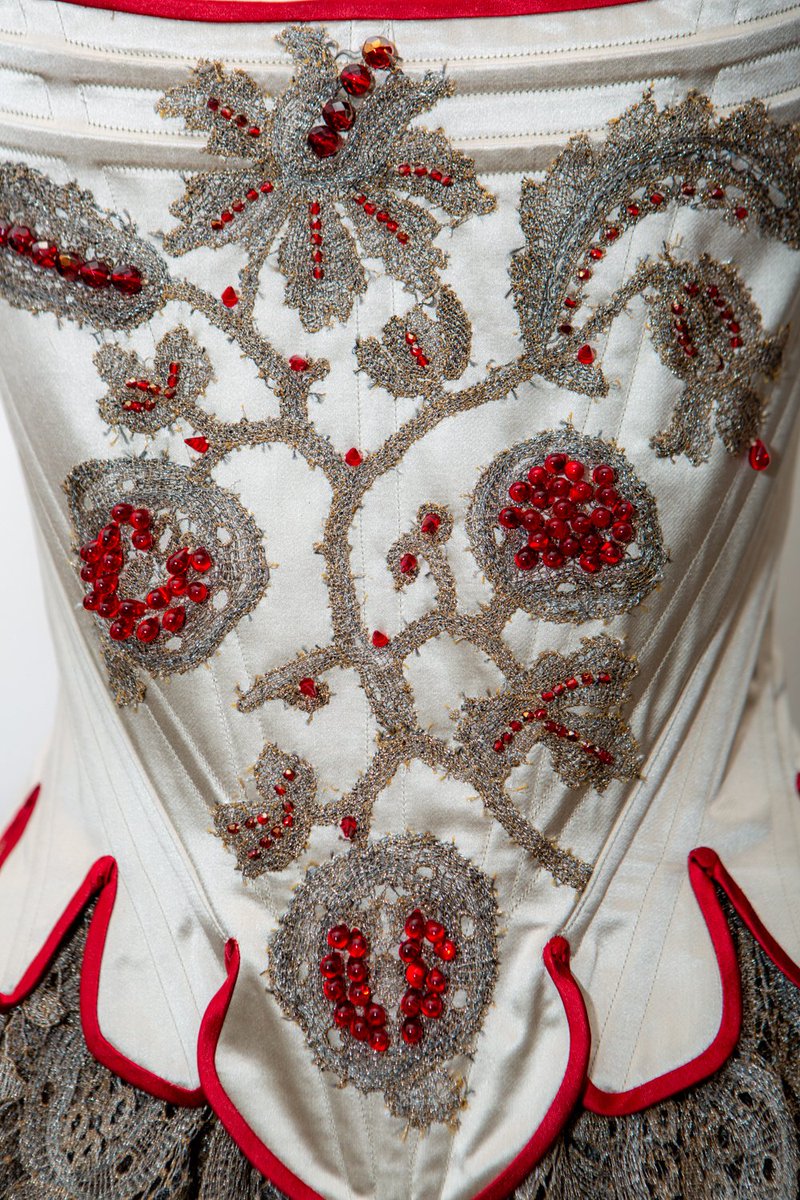 KarolinaZL's tweet photo. A close up look at the embellishment of the Persephone stays. Hand stitched guipure lace appliqué, in shades of silver and gold with pomegranate motifs. Czech glass beads, with droplets, metallic coated faceted beads, and delicate spikes. https://t.co/wbhQvcL63W