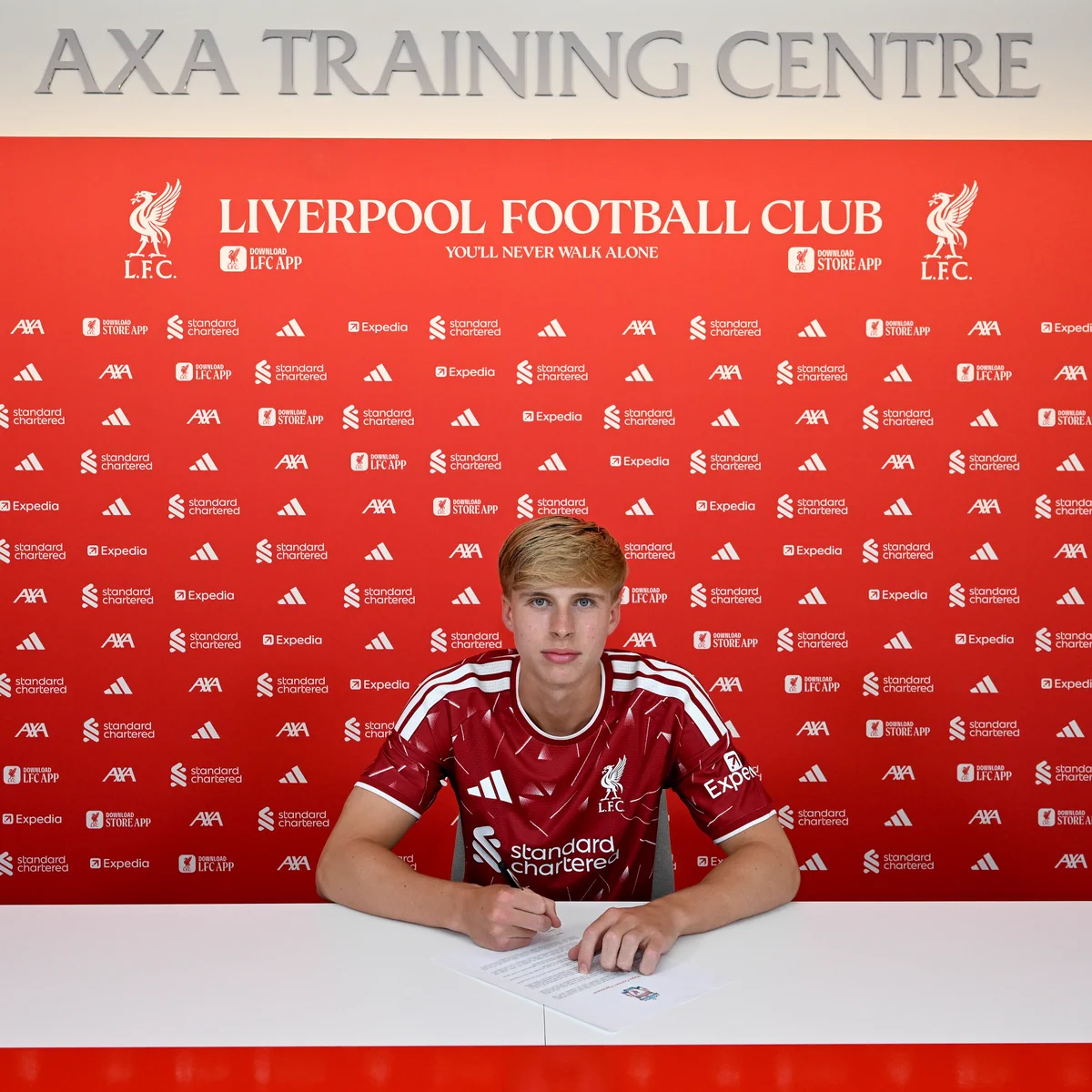 A photo of Oliver O’Connor signing his first professional contract with Liverpool FC
