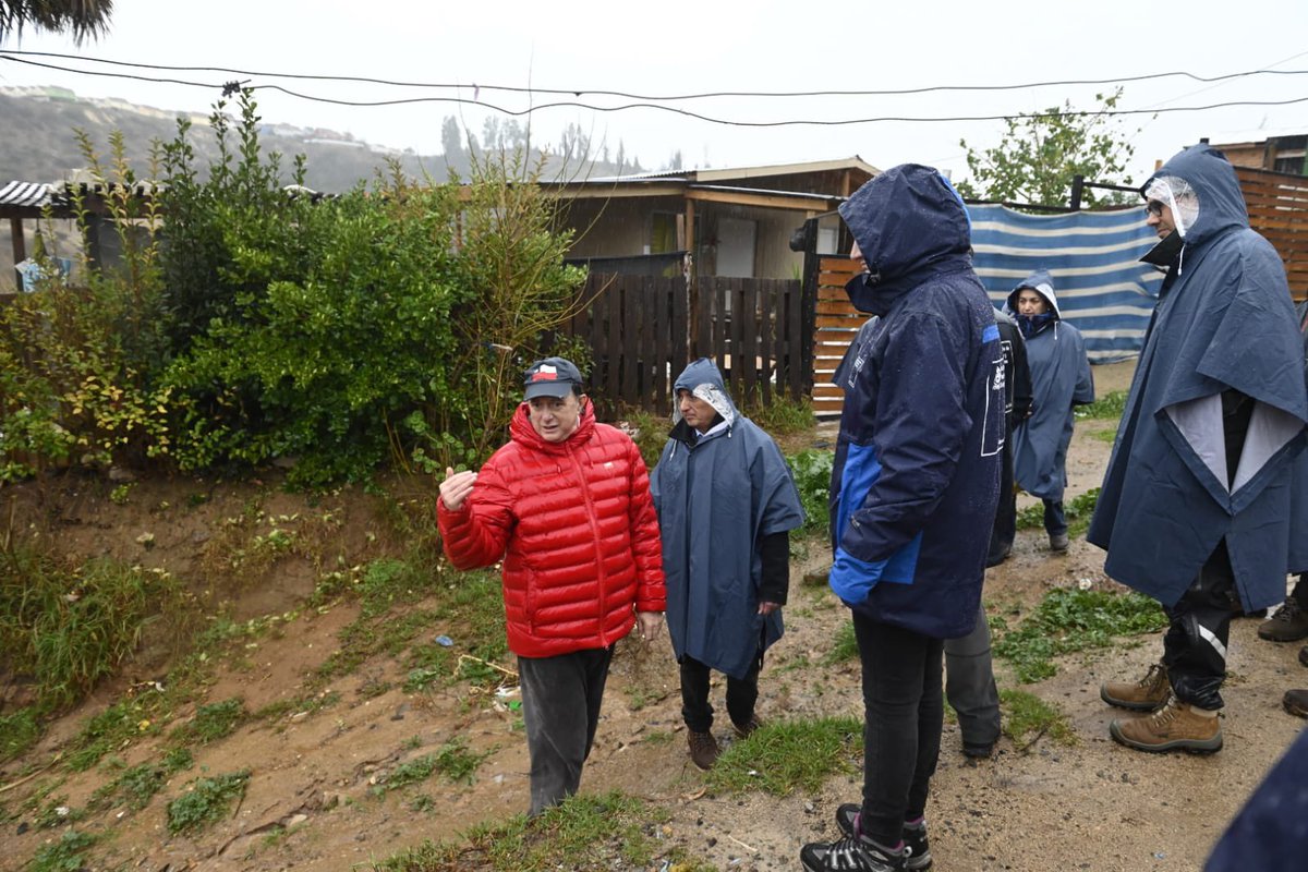 Minvu's tweet photo. Ante la denuncia de vecinos, el ministro Poduje inspeccionó las viviendas de El Olivar, donde un muro se desprendió tras las primeras lluvias. El hecho confirmó las fallas detectadas por DITEC e IDIEM. El Minvu instruyó su demolición para resguardar la seguridad de las familias🚧 https://t.co/WhbxLd1bvb