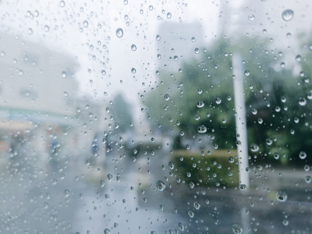 rei__katayama's tweet photo. さっき、大雨が止んで、太陽が出たとき、すごくうれしい出会いがあった。
配達先の近所で車をとめてりんごジュースを売っていたら、40代くらいのスーツ姿の男性とすれ違うときに「りんごジュース、いりませんか？」と声をかけると、空を指さしながら「今にも降りそうだから」と、小走りで去っていった。

ボタボタボタと降ってきた。
蒸し蒸しした空気が、急に重くなって、空がどんどん鉛色になっていく。横から雨が吹き込んでくる。雨粒がフロントを叩く。もう前が真っ白。雨音が激しく、ドドドドッと、車の天井を打ちつける。慌てて車内に避難する。
ワイパーが追いつかない。豪雨のピークが過ぎ去るのをじっと待った。
蒸し暑さが雨に冷やされて急に涼しくなって、太陽の光が薄い雲越しに、強く明るく差し込んできた。

行商を再開しようとハッチを開けたら、わずかにサイドドアの窓が開いていたようで、ジュースを入れてあるりんご箱に、雨が吹き込んで濡れてしまっていた。

タオルを取り出して、濡れた瓶を拭き始めた。拭いているうちに、ほかの瓶のホコリや小さな汚れに気づいて、一本一本、曇り空が瓶に映り込むほど丁寧に磨き上げていった。

80本あったジュースが、全て磨き終わる頃、

「さっきはすみません」

振り返ると、さっき走っていったあのスーツ姿の男性が立っていた。

「雨が激しすぎて、そこの店の軒先で雨宿りしながら、ずっと見てたんです」と、傘についた雨粒をふるい落としながら静かに話しかけてくる。

「瓶を拭くあなたの雰囲気が、ただの売り物を扱っているようには見えなくて。本当に大事に、ひとつひとつ磨いているのが伝わってきました。買いますよジュース」。

そういってカタログを覗きながら、「へぇ、店も世田谷にあるんですね」と明るくとても柔らかく品のある口調で色々と最近あったことを話してくれた。その方は、IT機器を企業に売る営業をやっている方だった。

「なんか丁寧に拭いてる姿を見ながら、そうだよなぁ、それがないとなぁ。初心に戻らないといけないな。と、最近の心のひっかかりの原因がなんとなくわかりました」と、美しく一礼をされ、予想していなかった展開に、「あぁ、いえいえ、こちらこそ、ありがとうございます」と、よくわからない生返事をしてしまった。

「こんな荒天の日こそ、空気を感じながら丁寧に過ごしていると、新しい発見や出会いがあるかもしれませんね」そう言いながら携帯を覗き込むその方の顔は、キレのあるとても精悍な顔だった。

もう会うことはないかもしれない一期一会の行商の世界で、なんとなくこの方とはまた、どこかで再会できるような気がした。

今までの記憶を振り返ってみると、行商の日常のほとんどは鮮明に覚えていない。わずかなきっかけがあれば、思い出すことは沢山あるはずだが、自ら記憶の詳細を呼び起こすためには、何かに書き留めていないと記憶の川に流されて、まるで無かったことのように情景を見失っていく。
これはほとんどの人に同じことが起こっているのではないかと思う。しかし、それではあまりにもはかなく、あっけない一生ではないかと思う。
ぼくは、同じ時間を生きている、すれ違い続ける人たちとの、全身で記憶するかのような一期一会の場面の瞬間、瞬間を、ひとつひとつの出会いの物語として積み重ねていきたい。