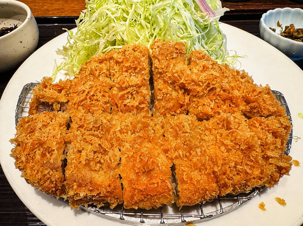 kudo_pon's tweet photo. 時価総額800兆円企業として知られるNVIDIAのフアンCEOが日本で食べたトンカツを食べてきた。うまい！

フアンCEOは富士通さん、ファナックさん、安川電機さん、川崎重工業さんらと食べたようだ。

調査したところ、とんかつ屋「ふみぜん 虎ノ門ヒルズ」(東京都港区)で食べたことが判明。フアンCEOの前に出されたとんかつの厚み・形状・カットから推測して「ハーブ三元豚特ロースかつ」(200グラム)を食べたとわかった。単品ではなく定食にすると税込1980円。

衣は極薄でサクサクだが、肉汁を吸ってシットリしている部分あり。ロース肉だが���身が多く、食べていて飽きずに最後まで食べられる仕上がり。

ソースは濃密だが穏やかな塩味(えんみ)と甘味で、コクだけが強い上質すぎるもの。塩にもマッチする仕上がりなので、ソース・塩どちらで食べても良き。調味料ナシでも食べてみてほしい。肉汁の���が良いから、そのまま食べても絶品だ。

この一等地で、この価格で、このクオリティならば、優秀なとんかつといえる。ちなみに、オンザライスしてからのソースがけ、これ最高オブ最高。

半導体グルメとして、エヌビディア飯として、実にハイスペックでハイエンドなとんかつだった。

うまい、うますぎる！