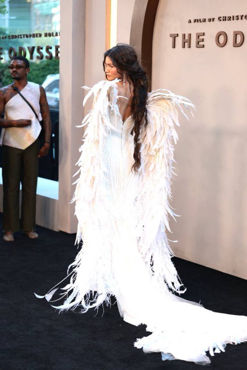 PolyokeyHenry's tweet photo. Red carpet chaos at Nolan’s The Odyssey premiere! Zendaya’s angel wing gown steals the spotlight, Anne Hathaway’s sparkling maternity look flawless. Matt Damon &amp; Tom Holland lead this stacked all-star myth epic. #TheOdyssey #Nolan https://t.co/k3vMoGJLLT