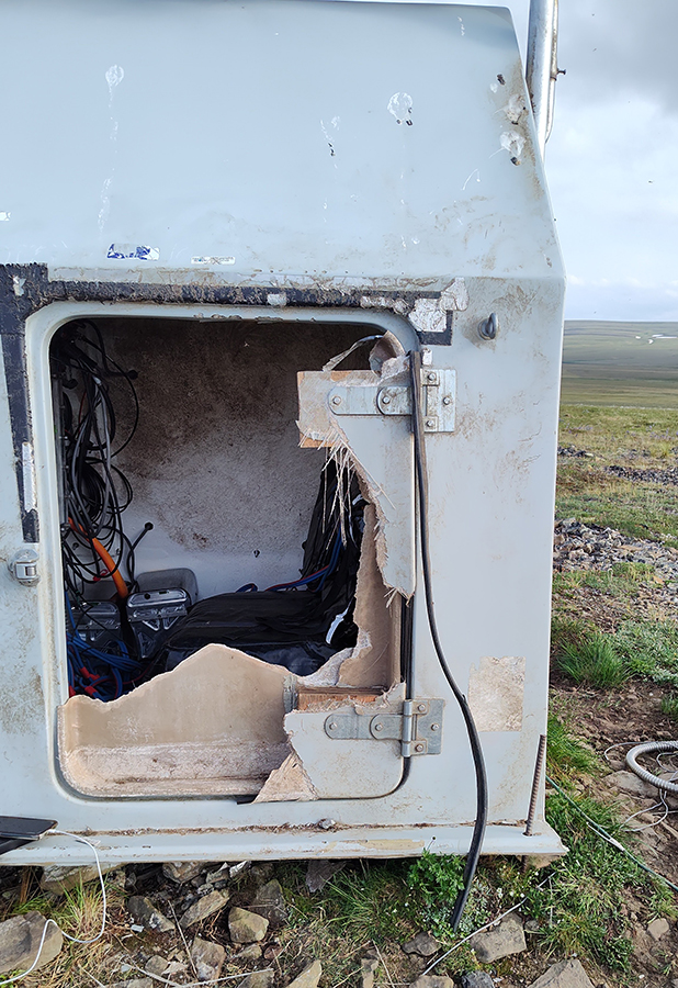 AKearthquake's tweet photo. It's #FieldworkFriday! Someone had fun taking apart B18K–and it wasn’t the field team! They arrived at this North Slope site to find extensive bear damage: a broken door, wires ripped out, and even several 75-pound batteries tossed 10 feet out of the hut. “It looked like the bear played in there,” said field engineer Shah Khan. “The bear left a calling card–a clump of hair stuck in the clamp.” One layer of batteries, zipped into a heavy-duty protective bag like a huge pizza bag, remained in place. “The batteries generate heat, so maybe the bear found a nice, cozy den for the winter.” Khan and field intern Chloe Crossen repaired the mess and got the station back online!