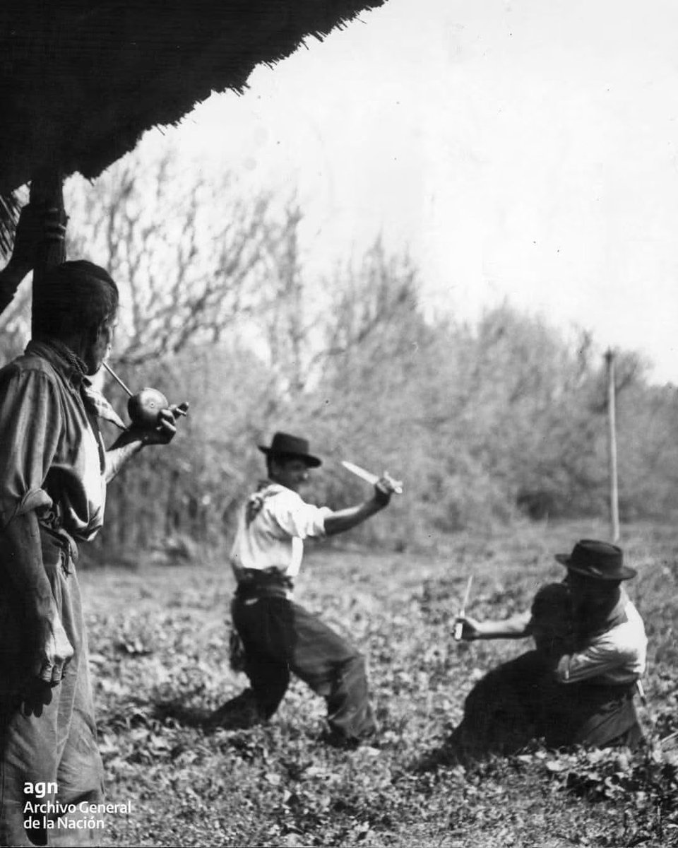 nfgfbpa's tweet photo. Gauchos resolvendo uma discussão.
El duelo criollo. 1939.
Destaque para índio mateando tranquilo mirando la pelea.      
📷 
Archivo General de la Nación Argentina https://t.co/edUWFy6aab