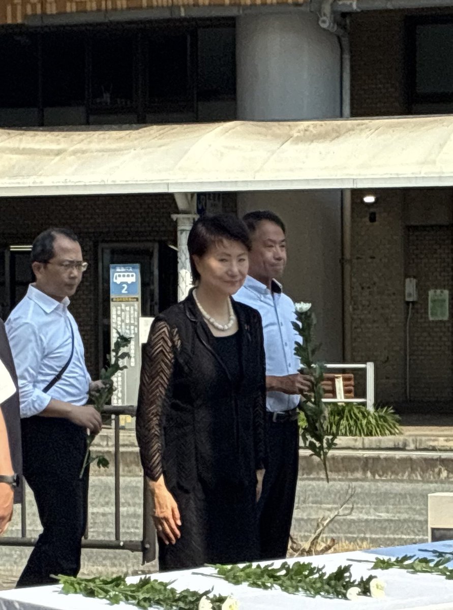 naomi_tokashiki's tweet photo. 昨夜、衆議院で国会会期延長の採決を終え、新幹線で大阪へ戻りました。今朝は、吹田市の「平和の塔祈念献花式」に参列しました。この式典は毎年7月、JR吹田駅前のさんくす夢広場で開催され、非核平和都市宣言の理念のもと、原爆犠牲者の御霊に哀悼の誠を捧げ、核兵器廃絶と恒久平和への誓いを新たにする大切な式典です。平和の塔は1960年に建立され、駅前再開発を経て1980年に現在の場所へ再建されました。塔の足元には広島・長崎の方角へ羽ばたく鳩の像と「非核平和都市宣言」の碑が設けられ、市民の平和への願いが今も受け継がれています。今年も子どもたちが心を込めて折った千羽鶴が奉納され、平和を未来へつなぐ尊い思いを感じました。戦争を知る世代が少なくなる今こそ、その惨禍を風化させてはなりません。平和は願うだけで実現するものではなく、守り育てていくものです。命の尊さを次の世代へ確実に伝え、核兵器のない世界と恒久平和の実現に向けて、政治が果たすべき責任を全力で担ってまいります。その決意を胸に、心を込めて献花させていただきました。