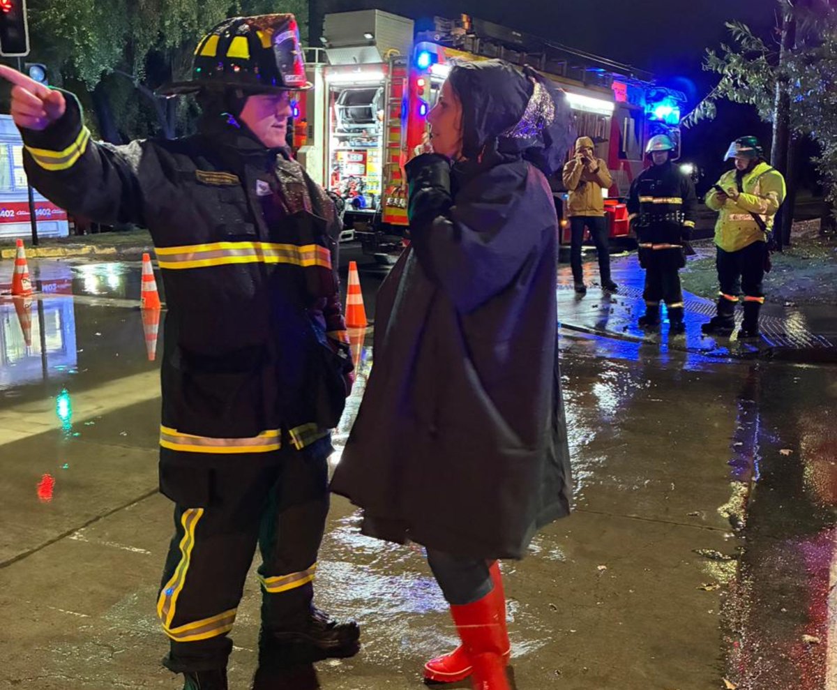 cbsantiago's tweet photo. 🔴 AHORA: el Cuerpo de Bomberos de Santiago apoya a @munilascondes ante desbordamiento de canal en Quebrada Honda y Francisco Bulnes Correa. En la imagen, el Superintendente del CBS, Álvaro Lara Alba, junto a la Administradora Municipal, Nayel Klein, durante las operaciones. https://t.co/6bThNiSGzW