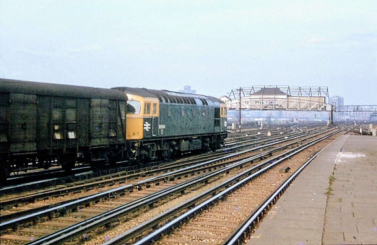 GarryBrookes56's tweet photo. CLAPHAM JUNCTION - summer 1977

A Class 33/0 BRC&amp;W diesel locomotive is heading a train of parcels vans departing the carriage sidings at Clapham Junction. https://t.co/1FN6574DTH
