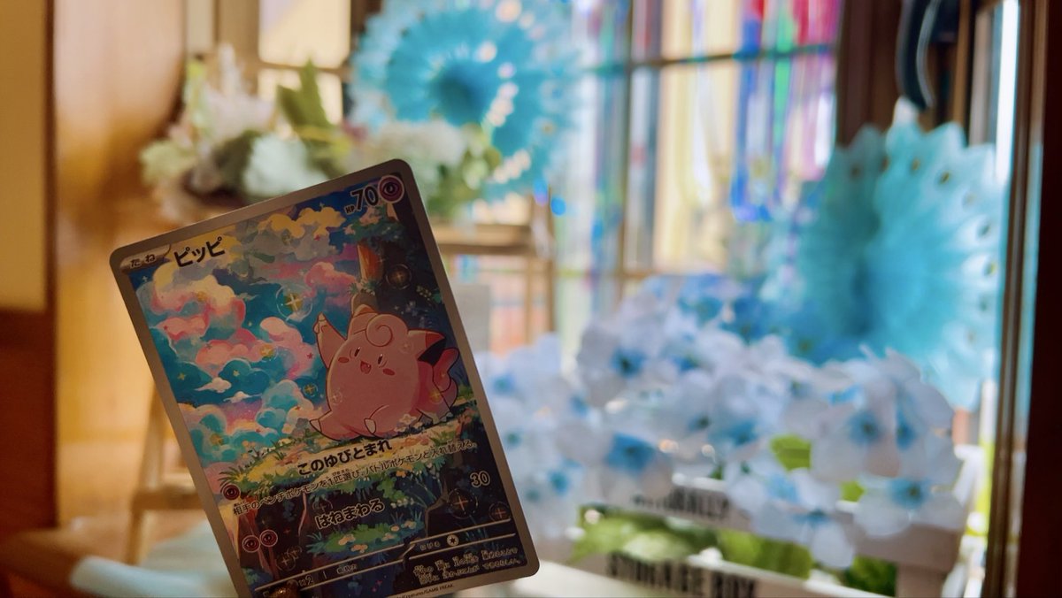 ito__pokeca's tweet photo. 喫茶店の入り口が夏仕様になってたので、ピッピとお写真📸🤍
カードの色味ともぴったりで可愛かった☺️
逆光すぎてカードが見えづらくて、チャッピーに助けてもらいました😂
ビフォーアフターも見てください笑
 #ポケカ #PokemonTCG #PokemonCards https://t.co/5Q0zwTNXzl