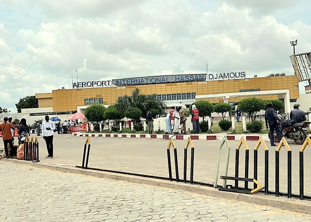 mouminkellehi's tweet photo. « Un aéroport international coincé en pleine ville, vétuste, saturé, sans âme.
Un hall qui ressemble à une gare routière poussiéreuse, où l’accueil se fait avec la peur : des agents qui intimident au lieu de rassurer, des proches relégués au parking comme des intrus.

Pas de duty free, pas de boutiques, pas de pub pour vendre le pays.
À part deux ou trois affiches de compagnies téléphoniques, rien qui reflète la culture, la beauté ou les richesses du Tchad.
Pas de bureau de change digne, pas de fierté nationale, rien.

Et pourtant, les billets pour N’Djamena figurent parmi les plus chers de la sous-région.
Pas pour la qualité du service, mais à cause des taxes. Des taxes démesurées pour financer quoi ? Certainement pas le confort des voyageurs.

On avait promis un nouvel aéroport à Djermaya. Première pierre posée en 2011, caméras et applaudissements.
En 2025, treize ans plus tard, rien. Juste des annonces, des protocoles signés à l’étranger, et un chantier invisible.
Pendant ce temps, on bricole la vieille piste de N’Djamena, comme si rafistoler l’humiliation pouvait lui donner des ailes.

Un pays pétrolier sans compagnie aérienne nationale.
Un État qui laisse ses citoyens payer le prix fort pour voyager dans la honte.
Voilà la vitrine que nous offrons au monde : un aéroport qui ne dit rien de nos richesses, mais tout de notre misère politique.

Un aéroport est une porte d’entrée. Chez nous, c’est une porte de sortie : celle d’un pays incapable de décoller.»