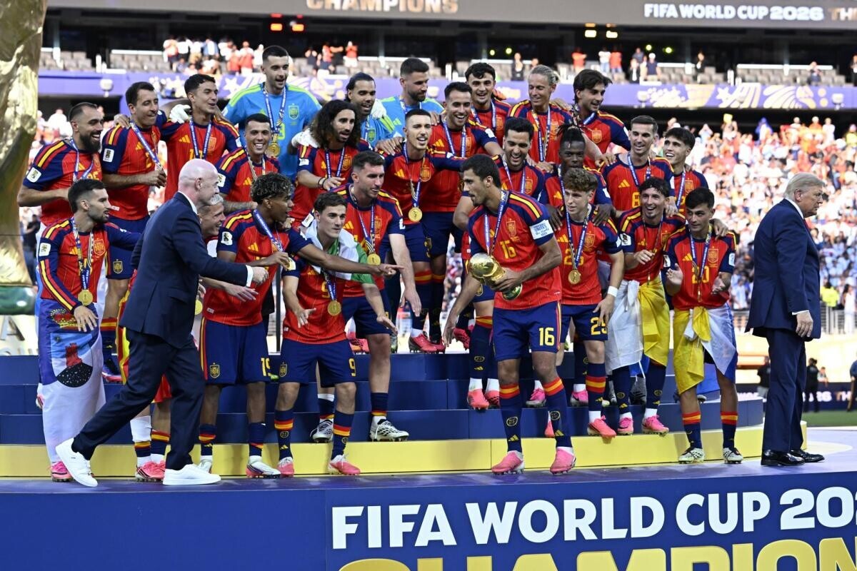 lequipe's tweet photo. Donald Trump s'est incrusté sur le podium quand l'Espagne a soulevé la Coupe du monde

➡️ https://t.co/nweEnzWdnY https://t.co/EN6kBjFyG5