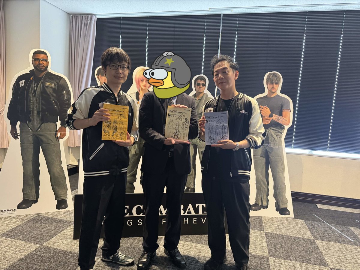 AvarikVonNom's tweet photo. On Saturday, July 18th, I and 20 other guests have had the honor of attending an early play session of Ace Combat 8: Wings of Theve.
Today the embargo imposed by Bandai Namco has been lifted and I can finally share some of my experience:

The event went as followed:
1) Introduction
2) 1 hour of game time, playing mission 4 and mission 11
3) Talk section with Kono Kazutoki (Brand Directior) and Shimomoto Manabu (Game Producer)

The introduction section was very brief, they gave us instructions on what we can and can't do, and then they presented Kono san and Shimomoto san to us. (I was sitting literally right next to Kono😳)
During that time we were also allowed to freely walk around and interact with Kono san and Shimomoto, so I took this opportunity to complete a mission I have started 5 and a half years ago, returning the Ace Combat 3 Voice Actors scripts to their rightful home.
This was made possible with the aide of GaiaBlitz, Krishty, Ribbon-Blue and Zanzor, each of which has donated to the cause of getting these voice actor books, after which I took upon the task of preserving them digitally and then ensuring they return home to Japan.
However after consulting with the JP branch of Bandai Namco, it was decided that I will keep these books and continue to preserve them, and so I shall.
I took a commemorative photo with both Kono san and Shimomoto san, each of us holding one of those books, I will filled with happiness but I was also very much nervous. ;w;

Regarding the game session, there isn't much new to be added to what is not already known and out there, I do wish to keep the spoilers to a minimum so I won't talk much about the story in the missions and keep details about the gameplay to a minimum.
I first started playing Mission 4 - The Fall of the Numbered Fleets, since I have very little experience with playing Ace Combat on consoles, I wanted to try out novice controls for once as I never experienced them before. (You can laugh at me all you want, I know I am not going to beat the novice allegations, I am cringe but I am free)
I gave the F/A-18C a try at first, it felt kind of sluggish but I had a good time flying around with it on novice controls, I event went through the tunnel.
After that, I played Mission 11 - Maximum Payload, on Expert controls, and felt more at home with the game.
It was kinda interesting to see sub-components weren't strictly attached to the largest aircraft in the mission, but also the smaller ones supporting them, seems like you have more ways to shoot down an aircraft now, which I find nice.
I must say that the overall game looks beautiful and plays great, it feels like a solid Ace Combat title and I very much enjoyed the return of the squadron controls and decision making.
While there wasn't really anything new that we don't already know, they did unlock the full aircraft roster shown in previous demo sessions, so I took this opportunity to give the Typhoon a try.
The multi-Special Weapon function is a nice addition and makes your aircraft far more versatile, at the cost of ammo capacity. (And it might need some getting used to, unless you played Ace Combat: Joint Assault or Project Wingman)
The return of Squadron commands and decision making (YES / NO) is much appreciated, and this time it seems that in the higher difficulties your squad mates are actually vital to both your survival and the mission's success, they can be quite brutal sometimes, and even defend you pretty well if you tell them to cover you.
I was also well impressed with the replay system, while it doesn't necessarily incorporate anything new, the pilot camera is a nice addition, and it's also nice to see the pilot respond and move based on the aircraft own's movement and flight direction.
Oh right, and the missile warning changed, it's not what we're familiar from other Ace Combat games anymore. :3c
Overall, the game felt like a mixture of Ace Combat 3, Ace Combat 5 and even some Ace Combat Zero sprinkled in, it may yet be one of the best Ace Combat games in the series.

As for the talk section, Kono san and Shimomoto san were asked questions made by all the guests attending the event, all of which were made before the actual event via a form, and only 8 of those questions made it to the talk section.
While my Japanese is still not very fluent, and I couldn't remember all the questions and answers, I do recall the following:
1) They were asked which of the characters the team were most fond of...and it was quite obviously, Tasha. :3
2) Assuming I got this right, while there are no branching paths in the game, it seems that certain decisions you make in the missions can affect certain things in future missions, though I had no chance to experience or confirm this, so take it with a grain of salt.
3) This is probably going to be the Ace Combat game with the largest amount of missions ever, though they did not give us specifics about how many missions there are.
4) If I understood correctly, The Land Battleship used by Sotoa was not originally planned to be implemented in the game, it was spontaneously thought of one day and then eventually became a reality.
5) They were also asked what particular things they were most detailed oriented with with the development of this game, and they said that they were detailed oriented with everything, but went all out with the sound this time, going as far as going to the US base in Okinawa to record aircraft sounds and also detonate explosives to record their explosion sounds.

Overall, I had a great time, and I want to thank from the bottom of my heart to Bandai Namco and Project Aces for giving me this opportunity to try out the game early and get some first impressions out for everyone else.
This has the potential to be one of the greatest Ace Combat games ever and I hope it will be so, I can't wait to try out the full game in October!
Once again, thank you so much! <3

By the way, the Nugget drawing was made by @DapperDapperDan, thank you very much! :3c

#ACE8 #ACECOMBAT8 #WingsOfTheve #ACE8先行体験会