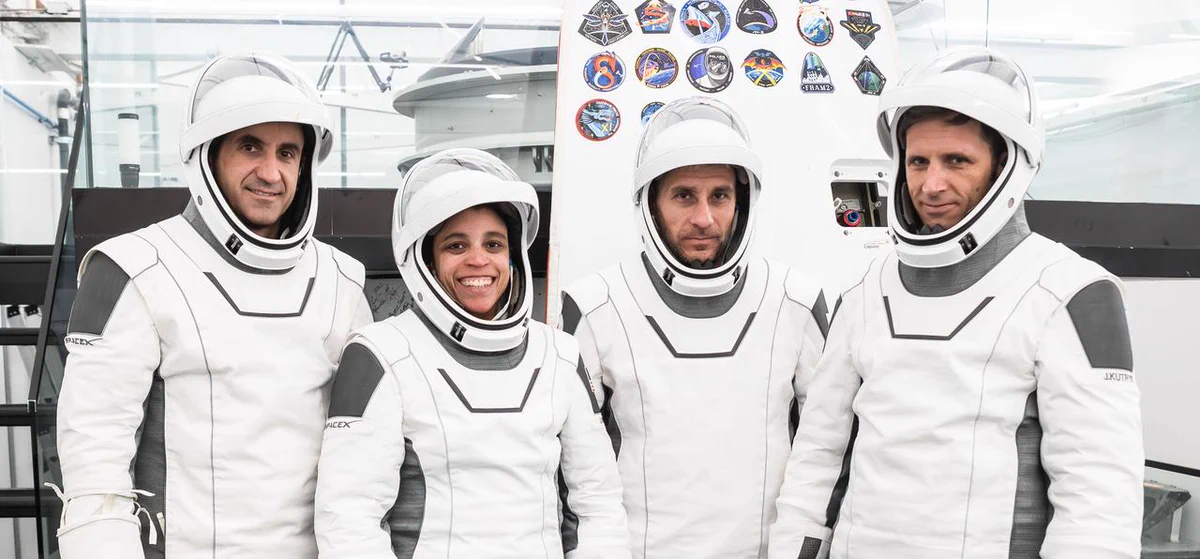 The SpaceX Crew-13 members pose for a portrait in their white and gray pressure suits during a preflight training session at the company's headquarters. From left are Roscosmos Sergey Teteryatnikov, NASA astronauts Jessica Watkins and Luke Delaney, and CSA (Canadian Space Agency) astronaut Joshua Kutryk. The pressure suits include a helmet. The visor is up on all of their helmets. Credit: SpaceX