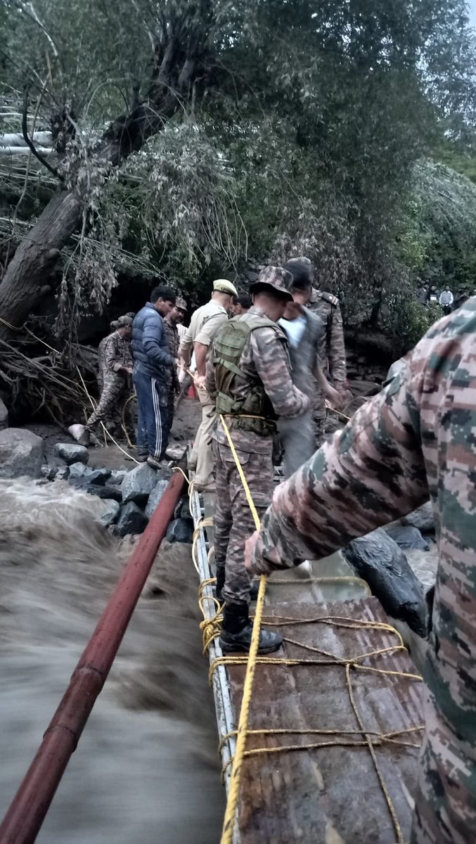 PS_Kargil's tweet photo. Flash flood damaged the Karkit Choo link road. A temporary footbridge was erected by the Indian Army, Kargil Police, UTDRF and locals, ensuring safe evacuation of stranded people. Army and Police remain deployed overnight for public safety. #FlashFlood @KargilPolice @DIPR_Kargil https://t.co/W7smwwDBDG