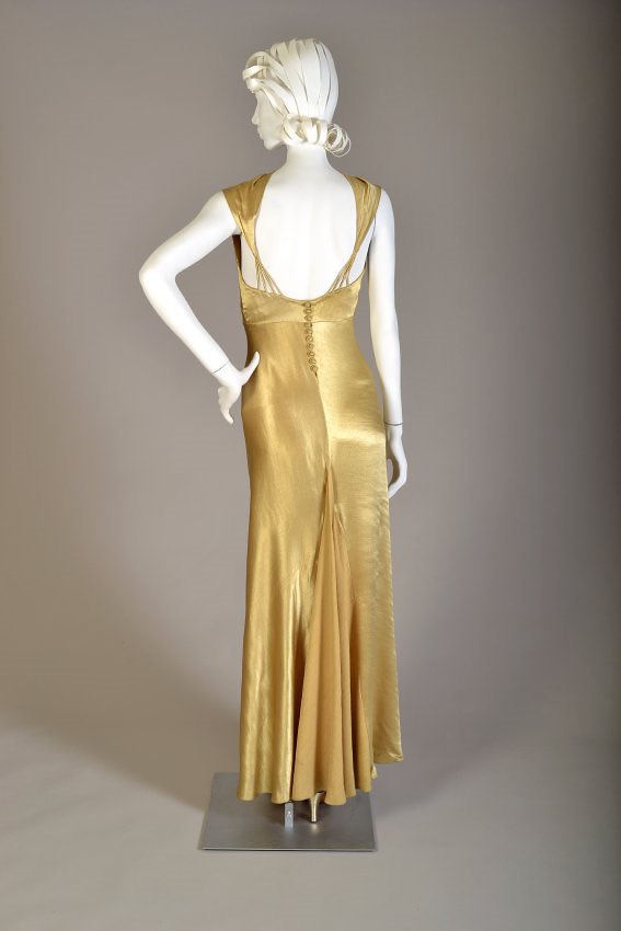 kateStrasdin's tweet photo. The edges of this gold rayon #1930s satin are so smooth that I can’t see the beginning or end of the short jacket that shrugs over the shoulders. It is only in its absence that you realise it is a separate piece. Bias cut and so very splendid @KSUMuseum #FashionHistory 🗃️🪡 https://t.co/jQB8Rj0qFh