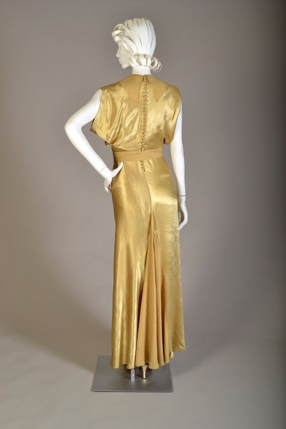 kateStrasdin's tweet photo. The edges of this gold rayon #1930s satin are so smooth that I can’t see the beginning or end of the short jacket that shrugs over the shoulders. It is only in its absence that you realise it is a separate piece. Bias cut and so very splendid @KSUMuseum #FashionHistory 🗃️🪡 https://t.co/jQB8Rj0qFh