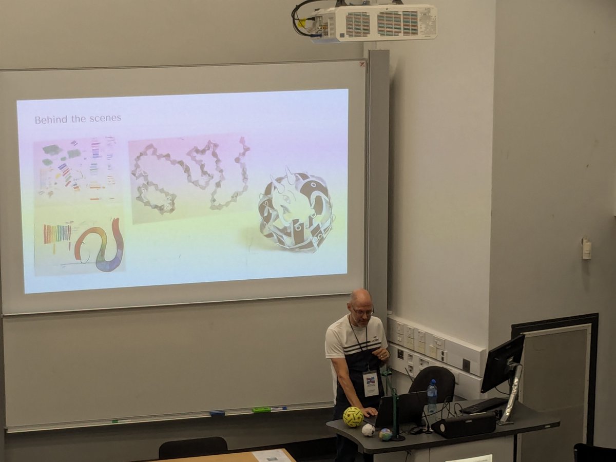 msmathcomp's tweet photo. The first afternoon session at the @BridgesMathart conference has David Swart speak about "Spaces Filling Curves" (https://t.co/PFkjk4bnzd). He employs an optimization algorithm to weave a strip of paper around a sphere, resulting in fascinating #MathArt patterns. (1/3) https://t.co/fHdDqsxLch