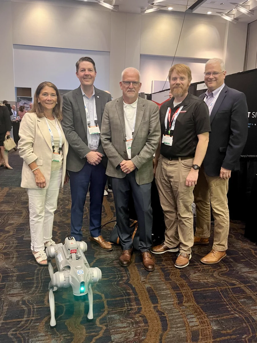 Representatives from TBR, Roane State Community College and Oak Ridge National Lab pose for a photo with a dog robot in front of them.
