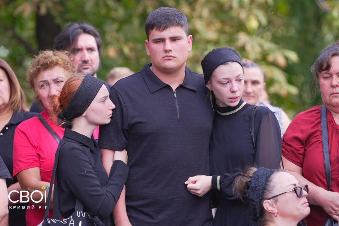 visegrad24's tweet photo. 23-year-old Ukrainian soldier Danylo Voronov with his sister & wife at today’s mass funeral of his family

A North Korean ballistic missile fired by Russia hit his family home in Radushne on July 30. It killed his:

- Father Artem (47)
- Mother Olena (41) 
- Brother Mark (17)
- Sister Dominika (15) 
- Sister Viorika (14)
- Brother Zakharii (12)
- Brother Ilai (11) 
- Sister Federika (10) 
- Sister Emiliia (6)
- Son Artem (1.5)