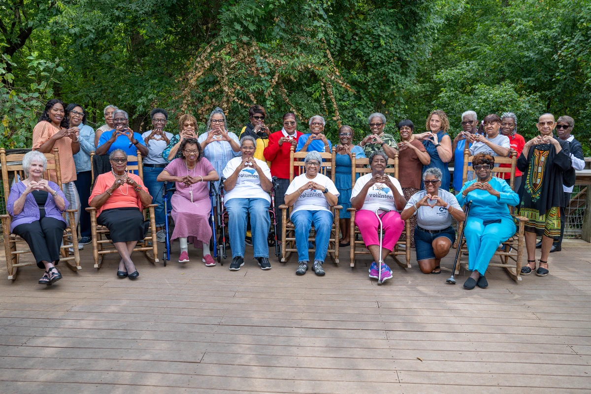 Dozens of grandparents smiling and posing for a phot 