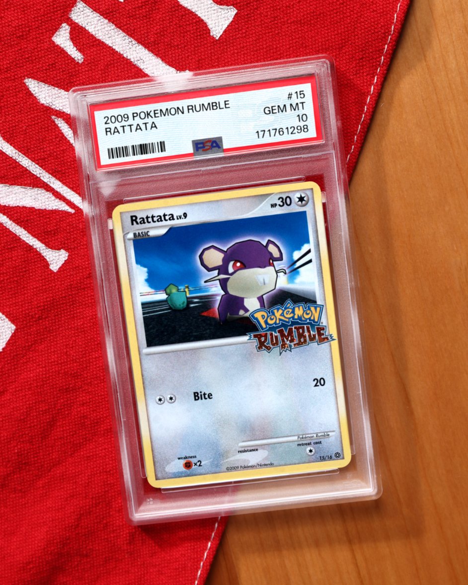 PSAcard's tweet photo. 𝙅𝙐𝙎𝙏 𝙂𝙍𝘼𝘿𝙀𝘿 🔬 One of Pokémon’s rarest gems is... Rattata?

It’s true. Released in a special collection tied to the WiiWare game Pokémon Rumble, this card replaces traditional art with the game’s chunky wind-up-toy model. 

It may not be the most conventionally beautiful Pokémon card — it is Rattata, after all — but it points to a very specific chapter of Pokémon gaming history.

PSA 10, Pop 12.
Graded on-site at The National.