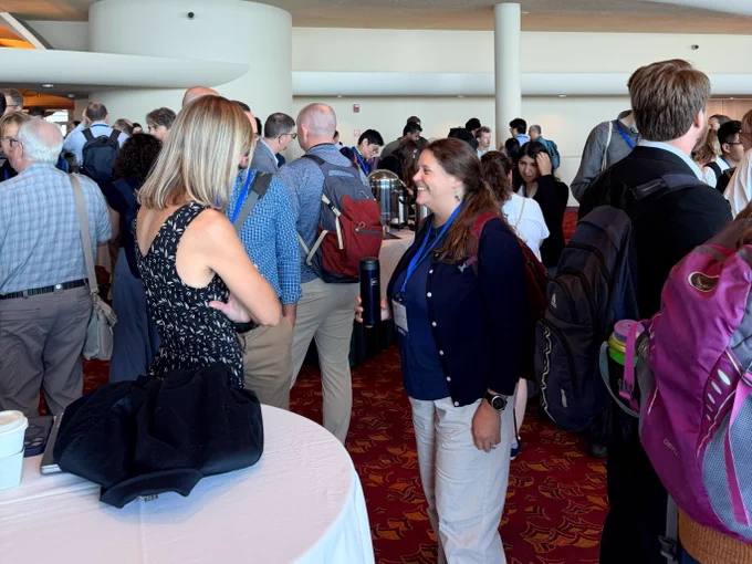 Attendees chatting during coffee break.