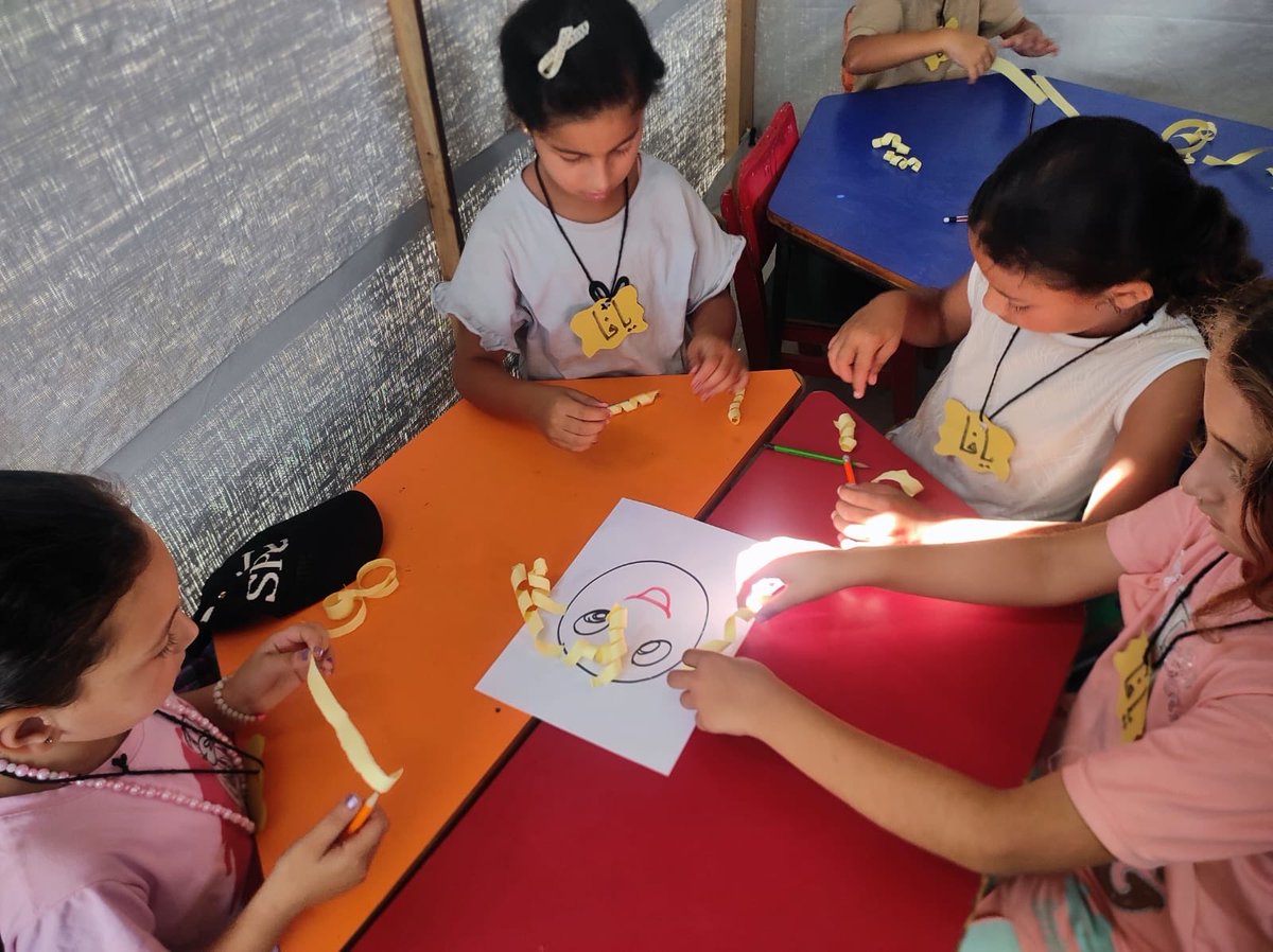 Play4Palestine's tweet photo. Paper spirals, careful hands, quiet focus. A small, ordinary joy — and in Gaza, that’s anything but small. #RightToPlay #Gaza https://t.co/yuwV3pAnwc