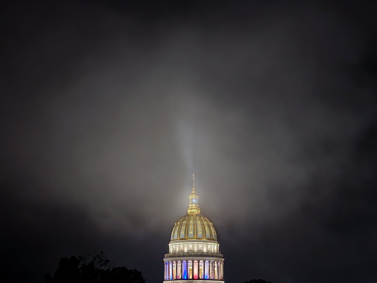 PerryB_Photo's tweet photo. A low-hanging cloud sits over the #WVCapitol tonight, as the State of Emergency beacon is lit, along with the red/white/blue colored lights that are still on in the collonade for America's 250th Birthday https://t.co/FKzhaqZEyq