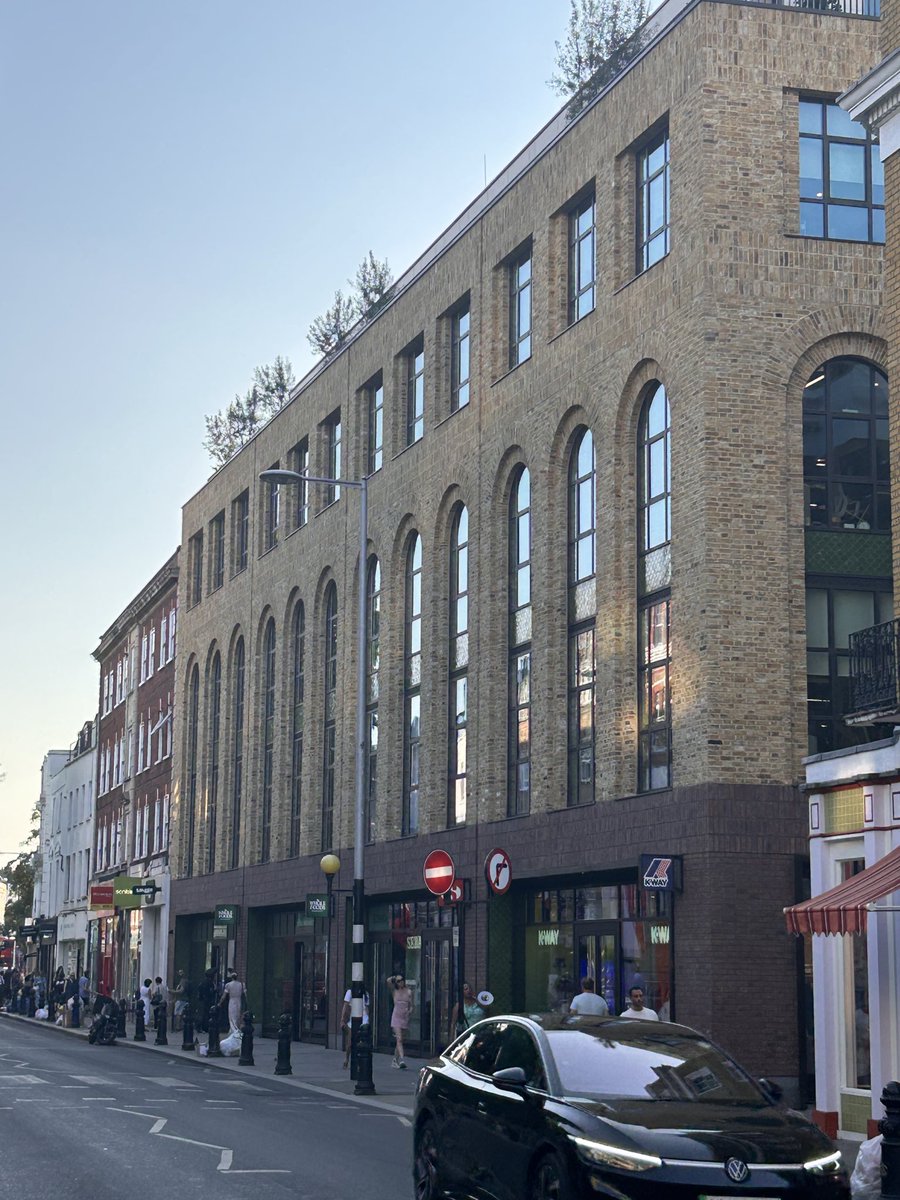 createstreets's tweet photo. Hope. This is new. Imperfect but sincerely street-friendly architecture. Absent any ornament or variety in a pattern, the glazing bars, the texture of stock bricks, the curves of the arches & the proper window reveals are left to do all the heavy here but they (just) rise to the challenge. 

(Shame about the risible street lamp).
