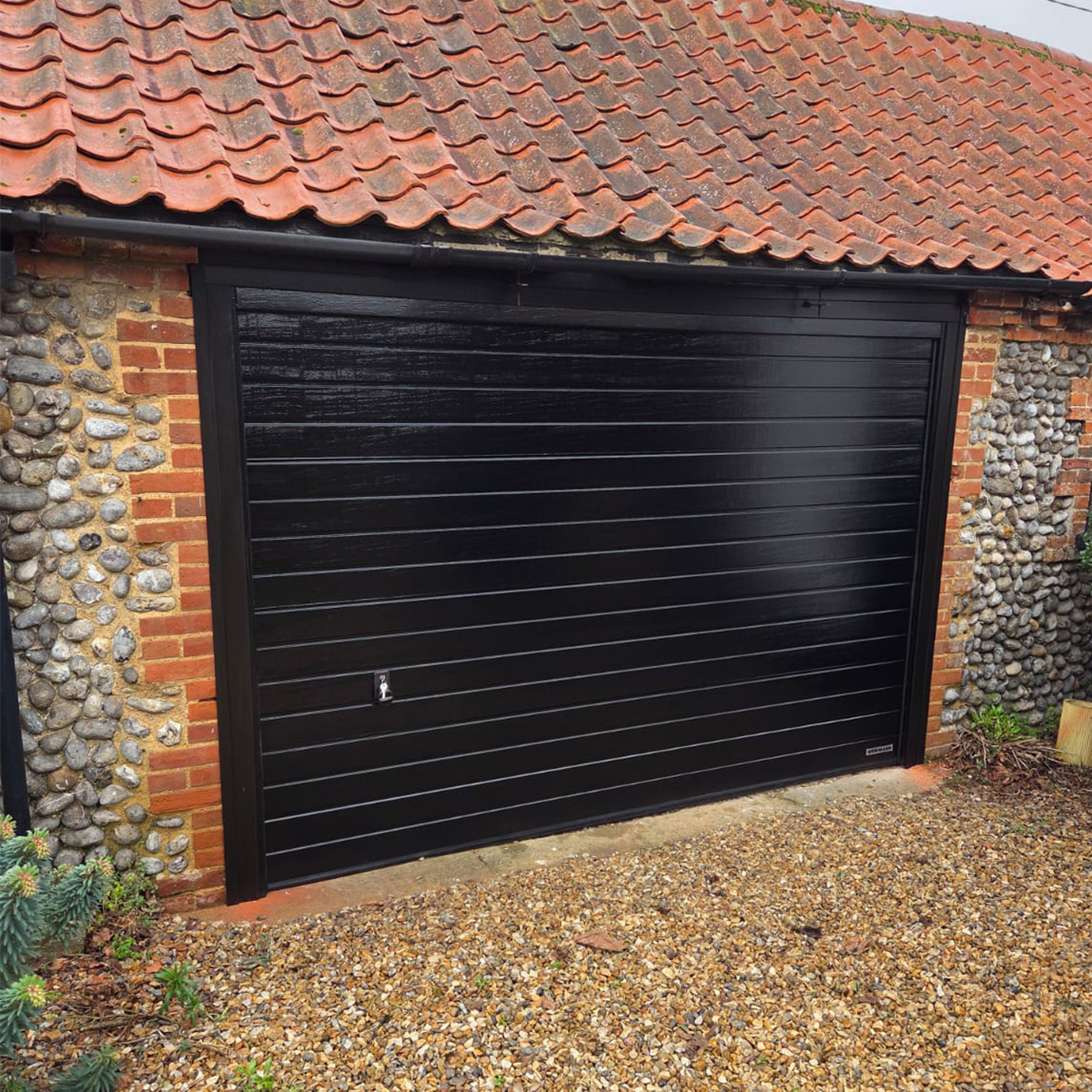 easterngroupuk's tweet photo. Modern black woodgrain meets rural charm in this sectional door installation. The sleek lines contrast beautifully with old brick, blending contemporary style with countryside character. #NorfolkLife #ModernMeetsRural #HomeStyle #EasternGarageDoors #SectionalGarageDoors https://t.co/zWl5BLkVsa