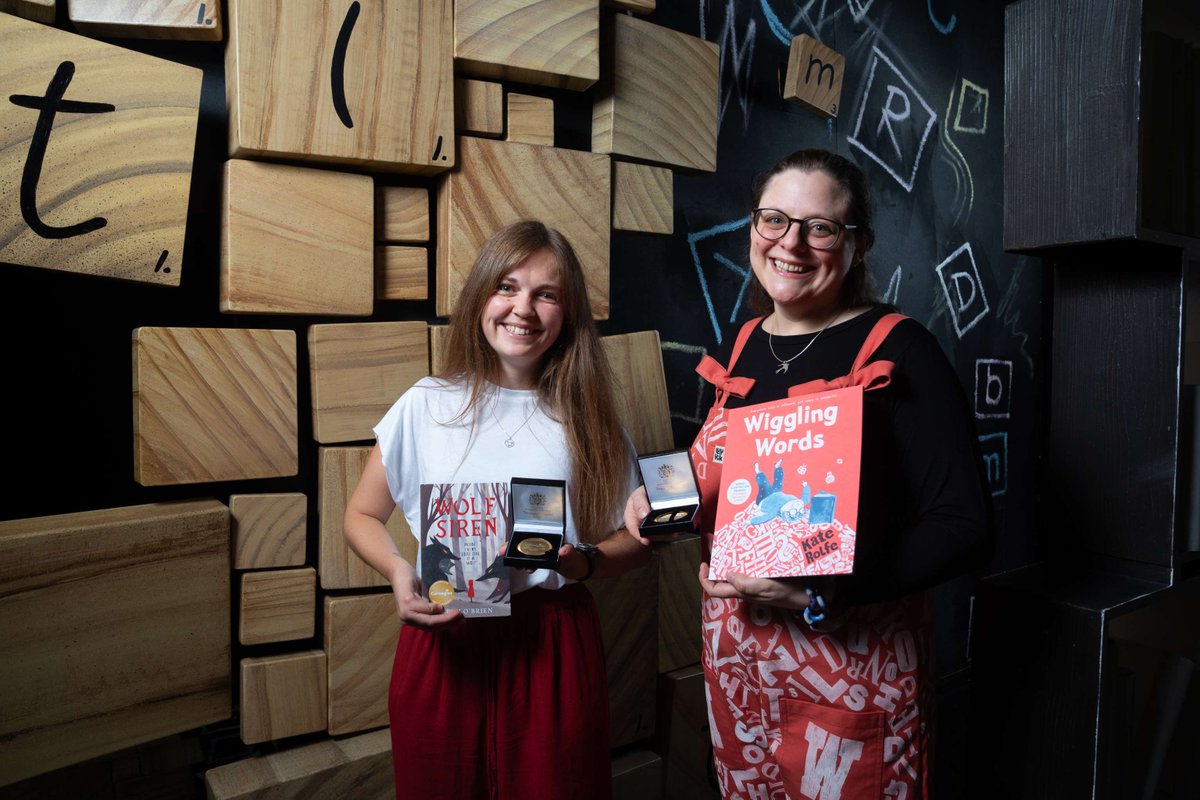 Beth O'Brien and Kate Rolfe pose with their medals and winning books