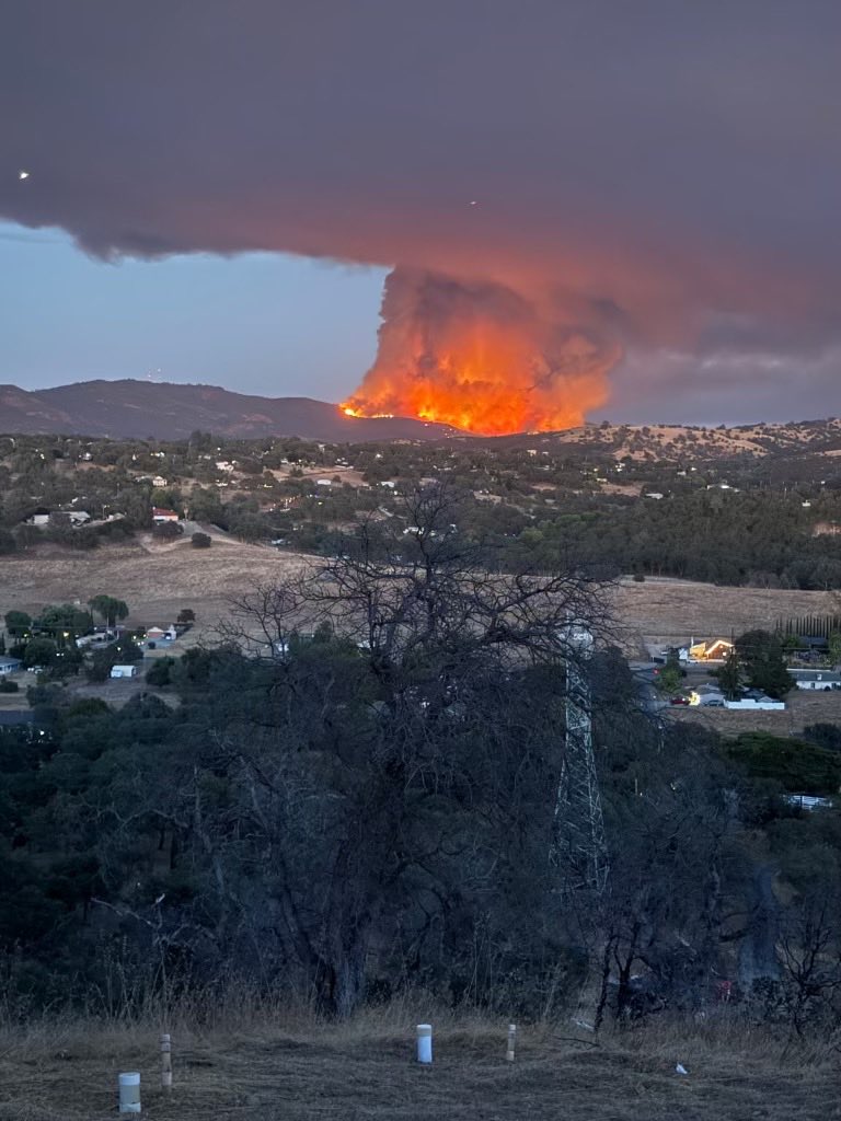HotshotWake's tweet photo. California: The Gann Fire is burning near New Hogan Lake in Calaveras county, and actively burned through the night. The fire remains active this morning and is estimated at 1,800 acres. 

The fire has been pushing south towards the old Walker Fire burn scar. Night capable helicopters have been active all night dropping water. Dozens of crews and engines, plus dozers have been ordered and on scene. Thanks to the subscriber who shared these views of the fire from his sister’s house.