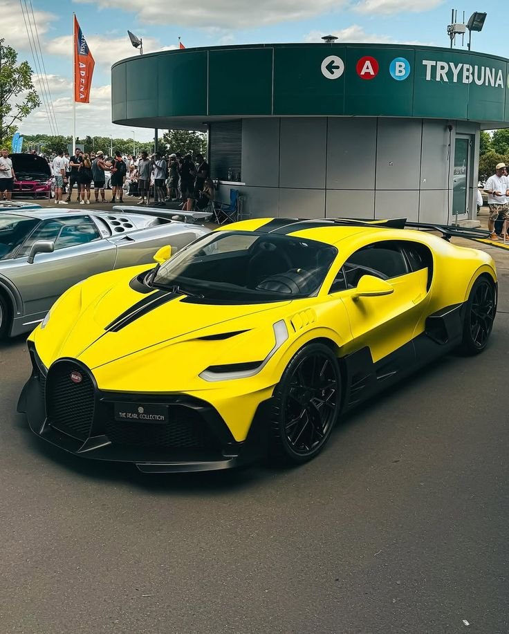 lukemablid's tweet photo. Vibrant yellow and black Bugatti hypercar commanding attention at the track event. 🏎️🔥 https://t.co/0Mi9yJUa3V