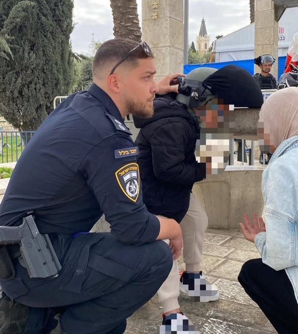 VividProwess's tweet photo. Israeli police officer shielding a Muslim mother and child, giving them his own helmet as ballistic missiles fly overhead.

The media will never show you this. https://t.co/gwLaIPL2Mf