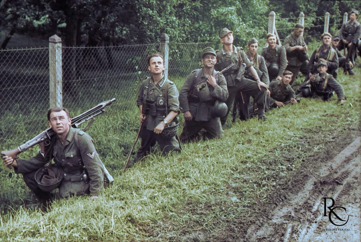 VoicesofWW2's tweet photo. “Low flying fighter in sight!” was the original caption to this picture when it was first published in 1944 in the German press.

For many years believed to have been taken in June shortly after D-Day, this photo is actually part of a set shot by KB Theobald depicting men of the 84. Infanterie-Division (probably Grenadier-Regiment 1052) moving in to relieve the 116. Panzer-Division prior to Operation ‘Lüttich’, referred to in Allied sources as the Mortain counterattack. This dates the set to the 2nd or 3rd of August, not June.
Given the urgency of the situation, the soldiers would most probably not be allowed to stop just to indulge a photographer, so Theobald probably took advantage of a short rest stop to snap this photo near La Haute-Louverie, a small hamlet halfway between Beauchêne and Ger (see comments for the spot today).
Typical of German divisions formed during 1944, the 84. Inf. Div. was a mix of decorated veterans transferred from other units and young recruits, some quite young from what we can see here. Of the first four men from the left, all veterans, three have the Infantry Assault badge, and the left-most NCO displays also a wound badge and what seems to be the EK2.
Unknown to these men, the division would not survive the August retreat to the Seine River, being destroyed in the Falaise pocket.