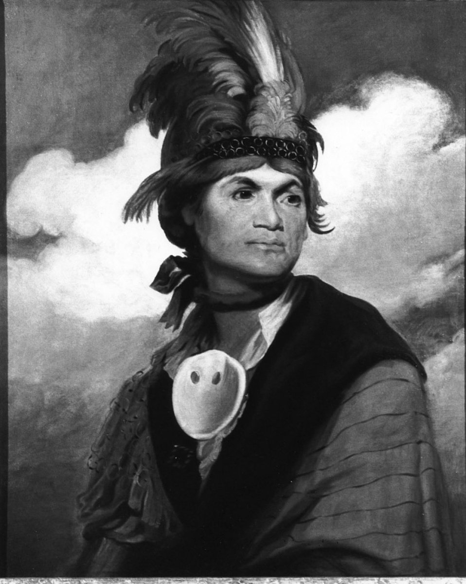 nmlinguaphile's tweet photo. The Mohawk people call themselves Kanien’kehá:ka, which means “People of the Flint.” That name comes from the rich deposits of flint (or chert) in their original homeland along the Mohawk River Valley in what is now upstate New York. 

Outsiders ended up calling them Mohawk after Dutch traders misheard a Mohican word that roughly meant “bear people.” Interestingly, the famous “mohawk” hairstyle you see today isn’t actually traditional for them—they traditionally left a square patch of hair on the back of the head rather than the dramatic crest most people picture.

They’re the easternmost nation of the Haudenosaunee, the People of the Longhouse, better known as the Iroquois Confederacy. In the Confederacy they were known as the Keepers of the Eastern Door, responsible for guarding the alliance against threats from the east. According to oral tradition, the Confederacy itself was founded by the Great Peacemaker (Dekanawida) and his spokesman Hiawatha. 

The Peacemaker traveled among the warring nations preaching peace, and after convincing the Mohawk, the message spread until the five original nations buried their weapons under the Great Tree of Peace. Historians place the formation of that alliance somewhere between the 12th and 15th centuries—long before Europeans arrived.

Culturally they were (and in many ways still are) a matrilineal society organized into three main clans: Turtle, Wolf, and Bear. Children belong to their mother’s clan, and clan mothers hold real political influence, including the power to nominate and remove chiefs. 

They lived in longhouses—communal bark-covered dwellings that could house multiple related families—and farmed the Three Sisters (corn, beans, and squash) while also hunting and fishing. Lacrosse has deep roots here; versions of the game were played for centuries as both sport and ceremony. One of the better-known modern legacies is the remarkable number of Mohawk men who became high-steel ironworkers. Starting in the late 19th and early 20th centuries, crews from Kahnawà:ke and other communities worked on some of the most famous structures in North America, including the Empire State Building and the George Washington Bridge. That reputation for fearlessness at extreme heights continues in some families today.

Traditional spirituality centers on the Longhouse religion, which emphasizes thanksgiving, the balance of natural forces, and the teachings of Handsome Lake (a Seneca prophet whose message spread widely among the Haudenosaunee in the early 1800s). Many Mohawk also practice various forms of Christianity, especially Catholicism, which took root in communities like Kahnawà:ke centuries ago. The two traditions often coexist in the same families and communities.

The language, Kanien’kéha, is a Northern Iroquoian language and one of the more complex polysynthetic languages in North America—words can pack an entire sentence’s worth of meaning into a single long form. It’s critically endangered, with only a few hundred fully fluent first-language speakers left, most of them elders. The good news is that immersion schools, adult classes, and community programs in places like Akwesasne, Kahnawà:ke, and Tyendinaga are producing new speakers, and some young parents are now raising children in the language again.

Today the Mohawk number somewhere around 45,000 to 50,000 people, with the largest communities in Canada—Kahnawà:ke and Kanesatake in Quebec, Akwesasne (which straddles the U.S.–Canada border), the Six Nations of the Grand River and Tyendinaga in Ontario—plus the Saint Regis Mohawk Tribe in New York. They remain politically active, culturally resilient, and deeply tied to both their traditional territories and the modern world.

Portrait of Thayendanegea (Joseph Brant), the well-known Mohawk leader, by Gilbert Stuart (1786)