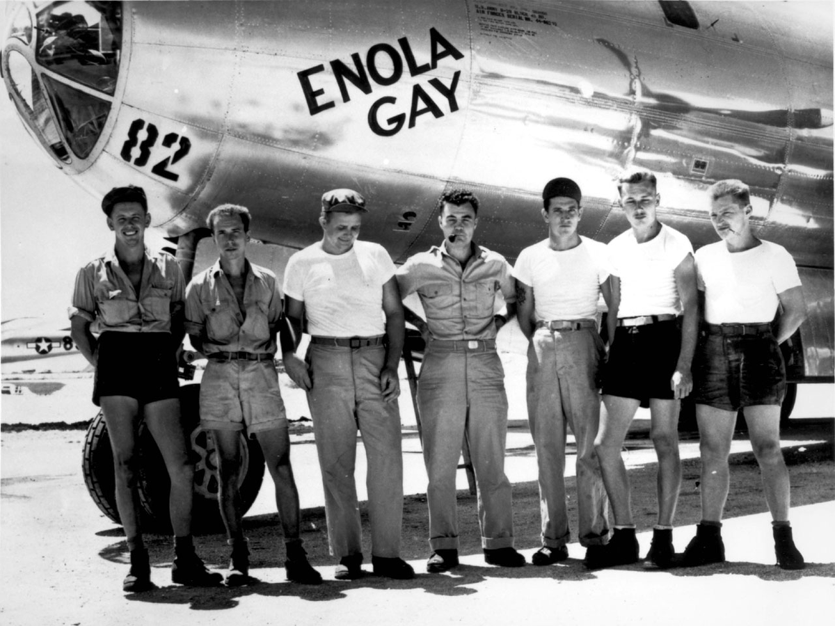VoicesofWW2's tweet photo. USAAF Colonel Paul Tibbets (center), flight crew member Theodore Van Kirk (third from left), and members of the ground crew for B-29 Superfortress bomber 'Enola Gay', Tinian, Mariana Islands, 5 Aug 1945 https://t.co/nGRPzVH7uC