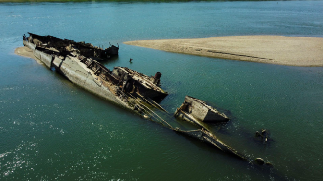 PhilipKAllan's tweet photo. This year’s heatwave and drought in Europe has caused historically low water levels on the River Danube, exposing over 200 German wrecks scuttled in 1944 by the retreating Germans, including this warship.

#GermanNavy #Heatwave #WW2 https://t.co/zWhpcJsNAH