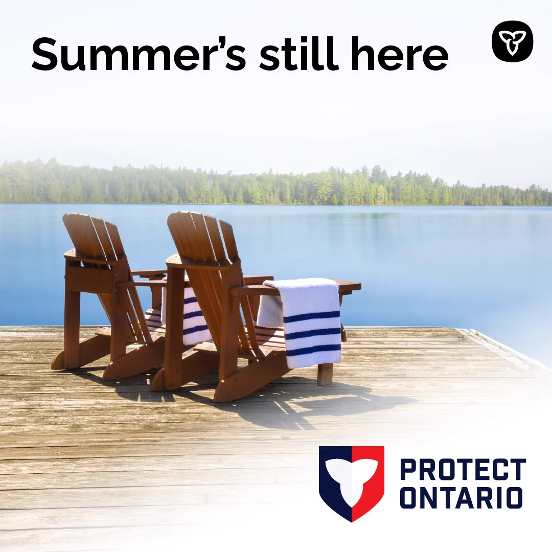 Two adirondack chairs on a doc overlooking a sunny lake 

Text: Summer’s still here
