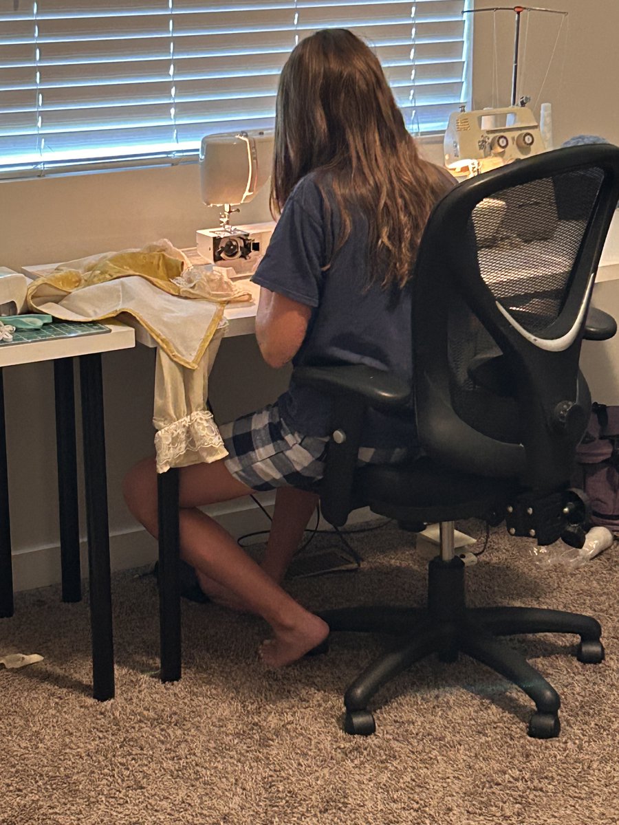 Principal_Jon's tweet photo. My 15 year old has spent most of her free time sewing this summer. 

She has created 5 dresses and one costume. 

Here she is working on dress # 6. 
This is early in the morning before breakfast.

When teens find a passion, you don't have to force the learning. 

This is education.