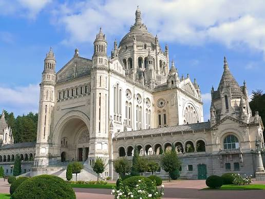 ThereseBaillard's tweet photo. La #Basilique Sainte-Thérèse de #Lisieux a été retenue pour représenter la #Normandie lors de l’émission « Le Monument préféré des Français » 2026. 
Sur le bourdon de 9 tonnes de l’une de ses cloches est inscrit la devise : « Je sonne l’appel des peuples à l’unité dans l’Amour » https://t.co/QHKcilBI42