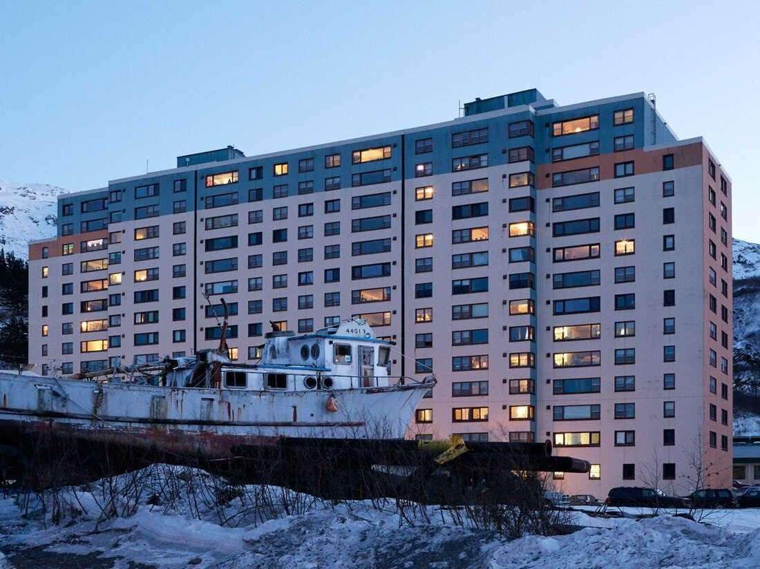 visualsofearth1's tweet photo. The Town That Lives in One Building. 🏔❄️

Deep inside a remote Alaskan fjord lies Whittier, a tiny town where most of the residents live under one roof.

The 14-story Begich Towers is home to apartments, a grocery store, post office, health clinic, church, laundromat, and the town's government offices. The local school is connected by an underground tunnel, allowing children to avoid the harsh winter weather.

Accessible through a single 2.5-mile tunnel carved through a mountain that shuts down completely at night, Whittier is one of the most unique communities in Alaska.