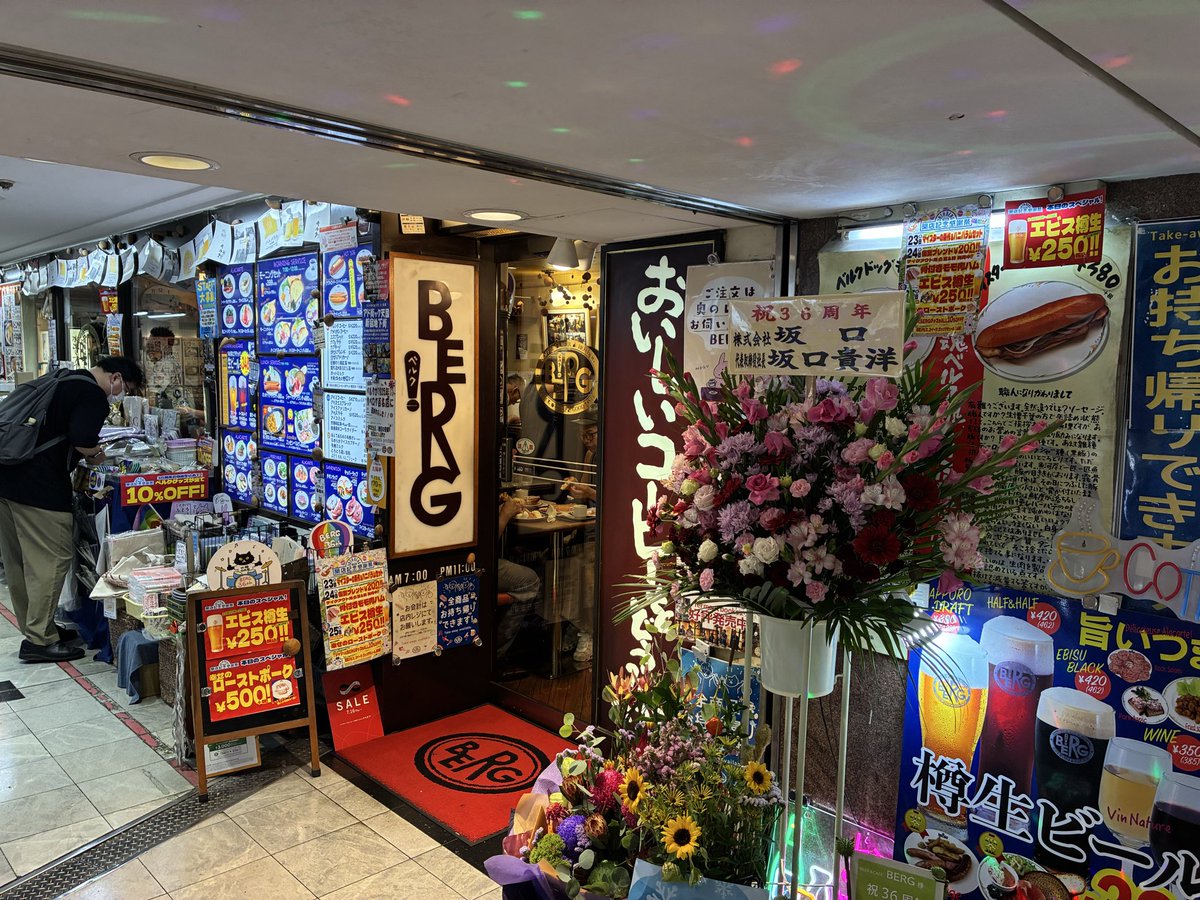 Bergzatsuyoten's tweet photo. お客様に大事なご報告があります。

狭いながらも大ターミナル新宿駅の一角を、お客様、スタッフ、業者さんと一緒に占拠して、今日で36年目になります。おめでとうございます🎉🎉🎉

お祝いで朝から一日中ヱビス樽生が1杯¥250（税込）で飲めます！！特別メニュー幸せのローストポーク1皿¥500+税もございます！！

ただの36年じゃありません。立ち退きにも負けず、コロナにも負けず、物価高にも負けずの36年。重みと深みが違います。

しかしよく持ちこたえました。だって、ベルクは駅の直営でも企業の系列でもありません。何の後ろ盾もない独立自営の店です。何より強力な支えが個々のお客様、個々のスタッフ、個々の業者さんだったとは！！何と感慨深いことか！！ふつーありえないことですから。

これはさすがに誇っていいんじゃないですか？家や職場で誇っても、ベルクをご存知の方が一人もいなければ怪訝そうにされるだけです。

よかったらベルクにいらっしゃって、ドッグやビールでも召し上がりながら、一人静かに勝ち誇りませんか？周りに知り合いが一人もいなくても、皆（お客様もスタッフも）同士ですから！お待ちしてます！！