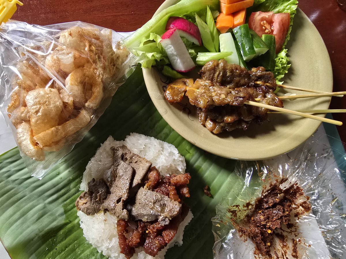 chettanaa's tweet photo. 先ほど買って来たチェンマイ式おにぎりの朝ごはん。ご飯のお供は豚バラ肉揚げと豚レバーのニンニク蒸しに豚甘串焼きも追加。けどこの食事の一番の決め手は赤唐辛子味噌󠄀でこれがなければ締まりに欠ける。これぞコンムアン（都人（みやこびと）＝チェンマイ人）の朝食だけどもう夜まで何も食べられない https://t.co/tSobMtgn89