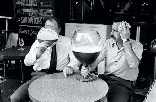historyinmemes's tweet photo. Two men cool off with oversized glasses of beer while sitting outside a cafe during a heatwave in Belgium, 1971. https://t.co/v6O7lieuUd