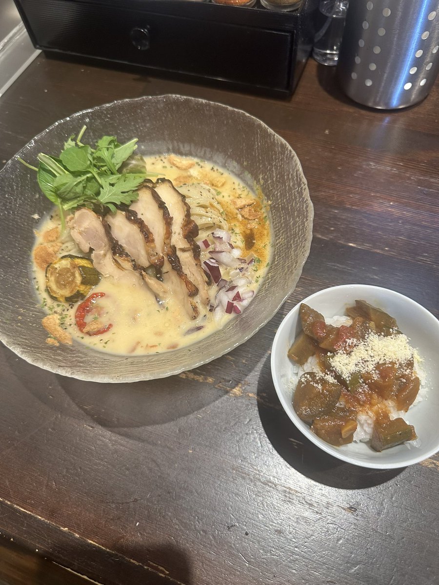 senjusan's tweet photo. ラーメンこころ
ヴィシソワーズヌードル
''冷たいじゃがいものポタージュ''
夏野菜のラタトゥイユ追い飯つき
先週桃に浮気して食べれなかったがリベンジに成功😏
TKC店主にも今週まででしたよと言われてしまったがよくぞ今週もやってくれたと心から感謝😭
''こころ''だけにな😱笑
そしてひと口スープを飲んでみると…これはやばい冷たいけど激アツ案件だわ🔥🤣
ここ最近こころさんでは甘々娘に始まり桃そしてヴィシソワーズとクリーミーな冷やしを頂いたがこれが1番好みかも🤤
どうもおいらは白っぽいドロっとした液体が好きなようだな🫣笑
滑らかな舌触りが心地いいポタージュスープはじゃがいもの旨みに散らしたハーブやスパイスが刺激を加え砕いたクルトン？やアーリーレッドが食感にアクセントを刻む😋
麺の絡みも抜群だし鶏チャをはじめズッキーニやドライトマトもいい仕事してるよね😙
そして何と言っても追い飯のラタトゥイユとヴィシソワーズのマリアージュにはマジでビビった😳
ちょっと何と言っていいかわからないけど食べた方なら''だよな''と同意してくれる自信あるわ🤣
来年は最初からラタトゥイユ入ってるんじゃね？と今から願望込みで期待しておこうかしら😂